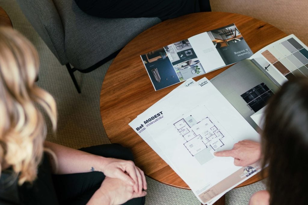 The House and Land Co team presenting custom home designs to a buyer