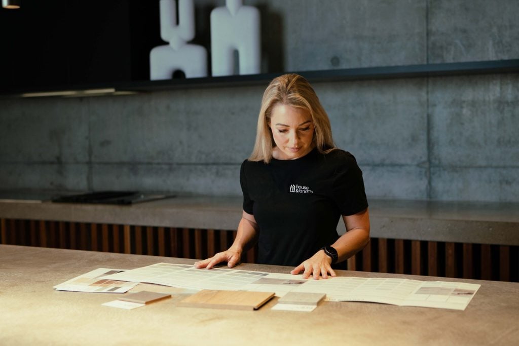 A House and Land Co consultant reviewing floor plans and material samples