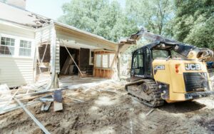 A bulldozer standing ready in front of a house due for demolition